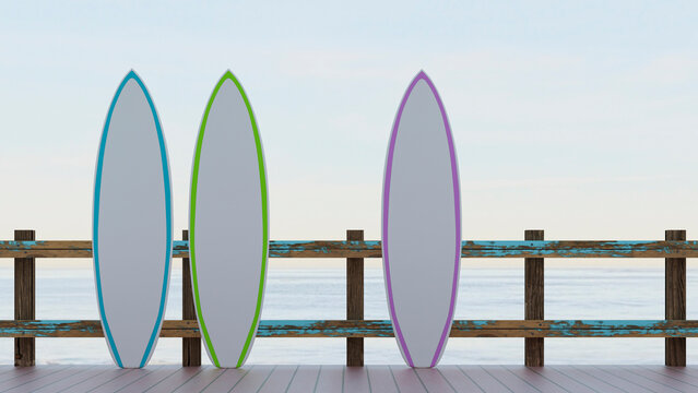 Three surfboards on a wooden dock fence during summer