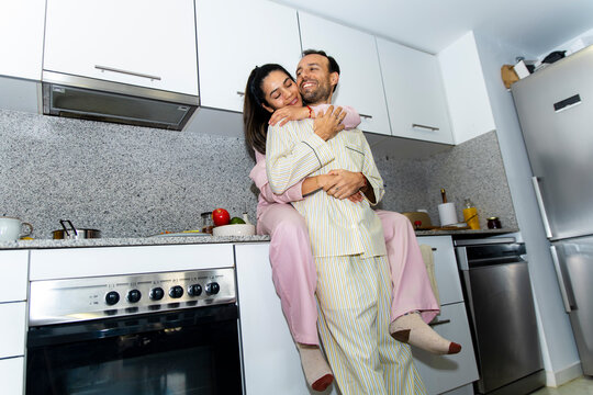 Happy couple hugging and enjoying quality time in the kitchen