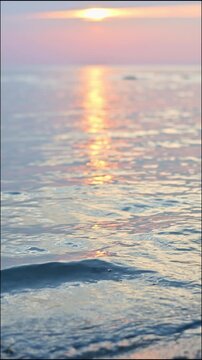 Vertical shot of beautiful blue water in the sea with little waves breaking to the beach under sunlight during sunset in Koh Samui. Thailand. Near focal length. 