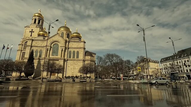 Smooth moving shot around the Dormition of the Mother of God Cathedral in Varna, Bulgaria. Winter wet day with passing cars and people. Varna, BG, EU, 22 february 2025