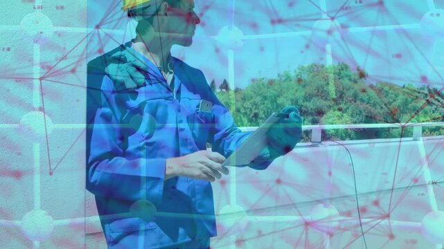 Worker tapping tablet donning helmet pointing and verifying building data under magenta net overlay