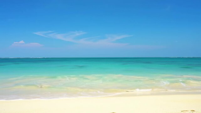 Pristine tropical beach, gentle turquoise ocean waves on golden sand under a vast azure sky with cirrus clouds, bright natural daylight. Concept of ultimate natural paradise