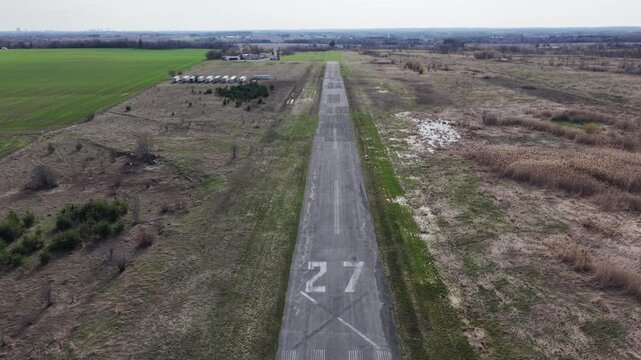 Close-up aerial view of the cracked asphalt and faded "27" runway markings at the abandoned Toronto Markham Airport (CNU8) in Ontario, Canada