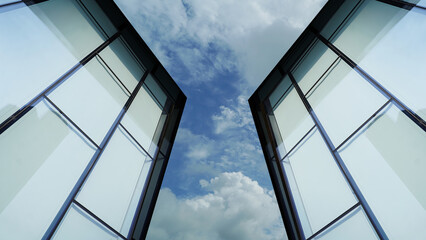 Architectural Detail of Glass Building Against Bright Sky © nana