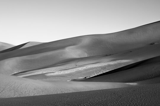Black and white sand dunes with dramatic shadows and sweeping curves at Great Sand Dunes National Park, Colorado