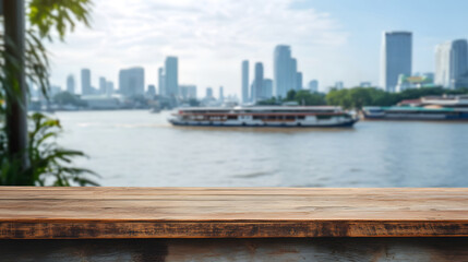 Obraz premium Wooden table top with blurred river city skyline and ferry boat in background, urban waterfront view with copy space for product display or advertising banner.