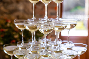 Close-up of stacked champagne coupe glasses filled with sparkling wine, creating an elegant celebration detail with soft bokeh © ugis