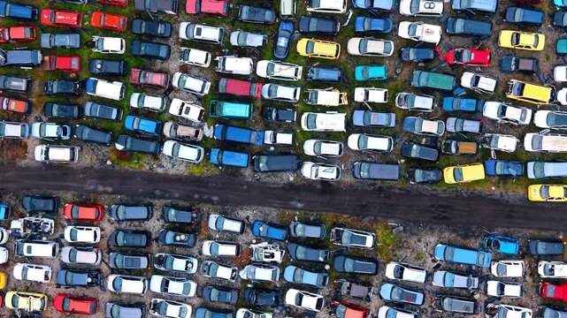 Top-down perspective of cars in an auto junkyard. Layout of used and damaged cars in a recycling facility area.