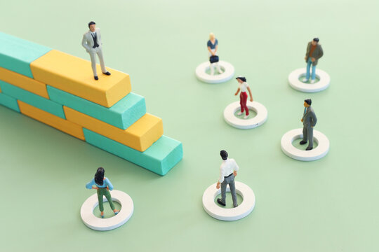 Concept image of a miniature figure progressing up a ladder to success and leadership