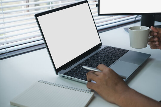 Remote work break moment holding coffee near laptop on clean desk, relaxed productivity scene in modern workspace, balance between focus and rest in digital workflow