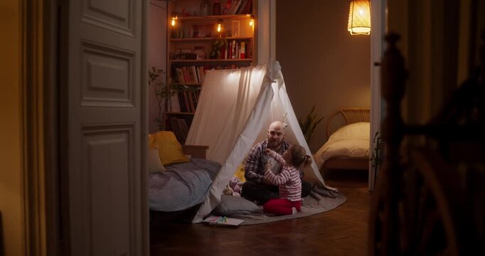 Two children build a whimsical fort in their living room, filled with joy and creativity as they play together