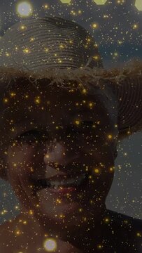 Vertical video: Senior woman closeup smiling squinting with sun causing gold flecks on face for ads