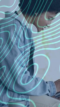 Vertical video: Man tapping tablet and causing turquoise line overlay while testing app design