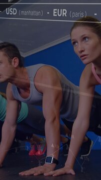 Vertical video: Duo planking for core in gym, camera lowering showing watch, finance ticker overlay
