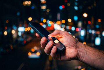 夜の街でスマホを操作する手元 © YUTO PHOTOGRAPHER