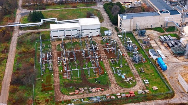 Aerial view of power substation and industrial infrastructure. Detailed top down shot of high voltage transformers and power lines at an industrial site.