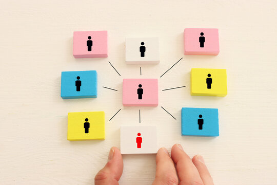 Wooden cubes and hand picking the leader. Idea of collaboration and teamwork