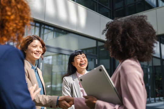 Businesswomen shaking hands after successful team meeting outdoors