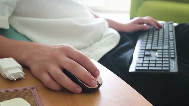 Close-up of Person's Hands Using Wireless Mouse and Keyboard While Working Remotely at Home