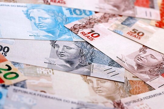 Brazilian real money bills pile on table. Brazil banknotes of BRL currency close up.