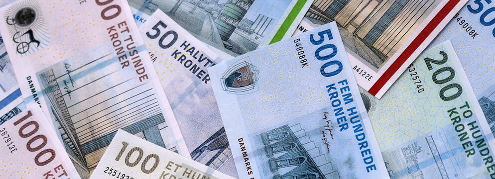 Danish krone money bills pile on table. Denmark banknotes of DKK currency close up.