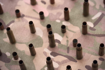 Obraz premium Big amount of shells cartridges from assault rifle bullets on old camouflage fabric