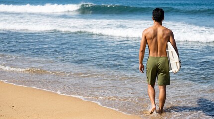 Fototapeta premium Asian man walking with surfboard on sandy beach by the ocean.