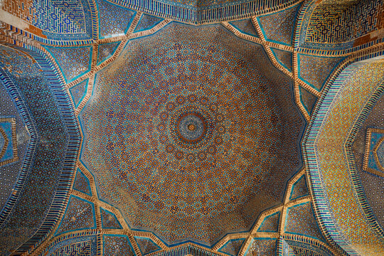 View of ochre and blue traditional floral and geometric design inside cupola of ancient Shah Jahan mosque in Thatta, Sindh, Pakistan	