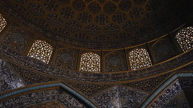 Low angle view of the dome of Sheikh Lotfollah Mosque in Isfahan, Iran, showing detailed Persian tile patterns and Islamic architecture. Famous historic mosque located on Naqsh e Jahan Square