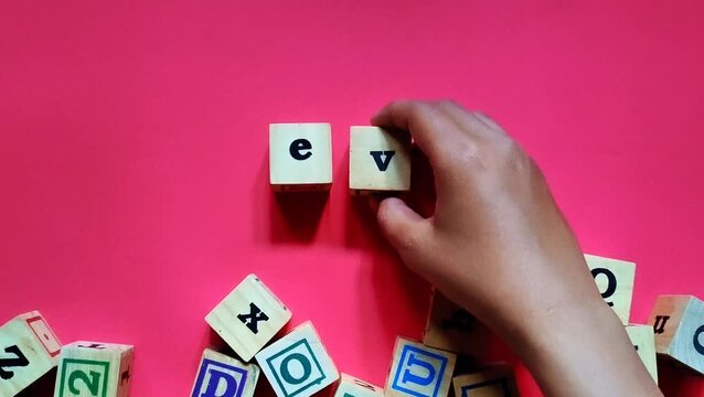 Footage of a hand arrangement wooden cubes spelling EVP or Employee Value Proposition isolated on red background. Concept of highlights HR strategy, talent attraction, and organizational value.