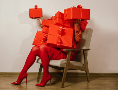 Overwhelmed housewife covered in red gifts sitting on a chair