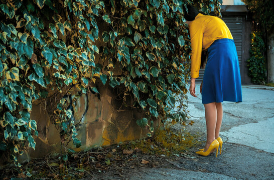 Housewife with burnout hiding her head in a green outdoor bush