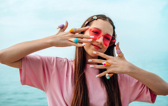 Smiling girl in pink sunglasses by the sea on summer vacation
