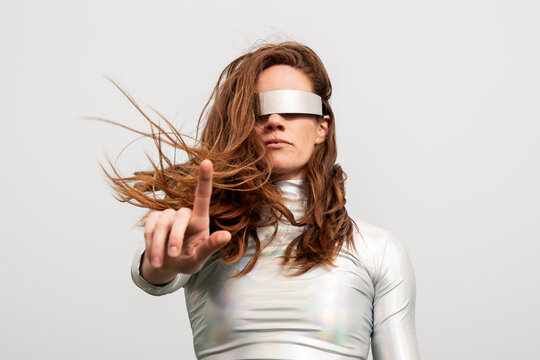 Model outdoors using virtual reality visor in metallic clothing
