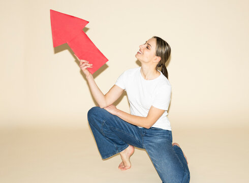 Businesswoman holding red paper arrow for growth strategy