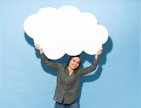 Smiling model holding a paper cloud on blue background