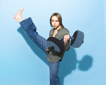 Athlete kicking high with paper dumbbell showing effort