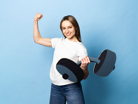 Smiling model holding paper dumbbell and flexing bicep