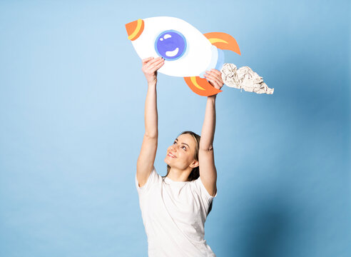 Woman holding a handmade paper rocket to symbolize success and ambition