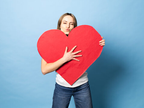 Model holding red paper heart expressing love and authenticity