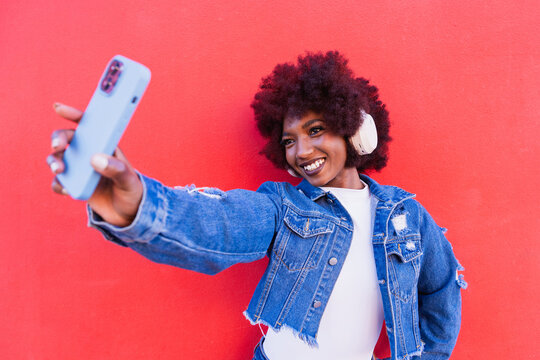 Smiling taking a selfie with smartphone and headphone