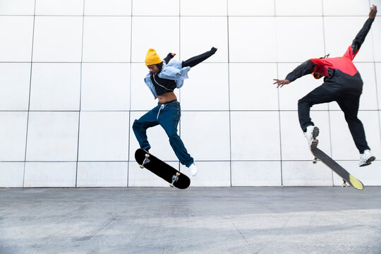 Skateboarders performing synchronized trick outdoors in Barcelona