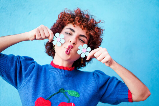 Redhaired model holding flower and making funny face