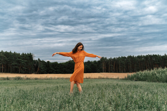 Carefree woman dancing amidst crops in field