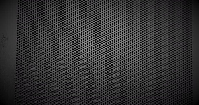 Black Perforated Metal Mesh. Smooth slow movement across extreme close-up of dark perforated metal grid with dramatic side lighting.