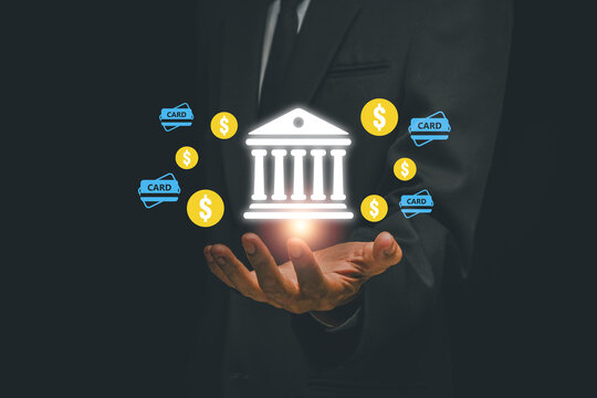 Businessman holding digital banking icons, symbolizing fintech and online transactions, in a modern business setting.
