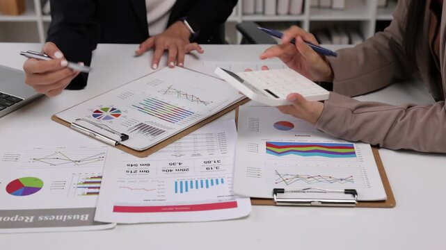 Businesswoman analyzing financial reports and graphs during a meeting.