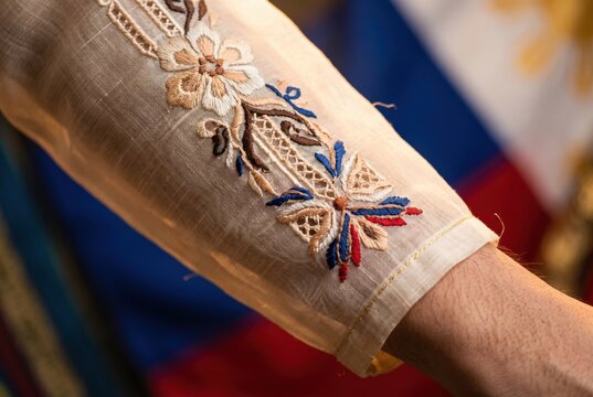 Embroidered sleeve of a barong tagalog on a person highlighting traditional floral patterns for fashion editorials, cultural garment studies and textile industry assets