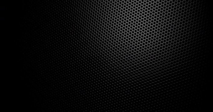 Black Perforated Metal Mesh. Smooth slow movement across extreme close-up of dark perforated metal grid with dramatic side lighting.
