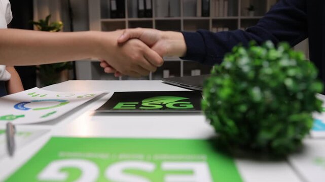 Business people discussing environmental, social, and governance criteria. Colleagues shaking hands, sealing a green business deal.